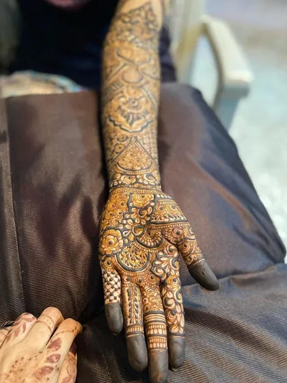 A side view of the bride's arm, showing the intricate patterns.