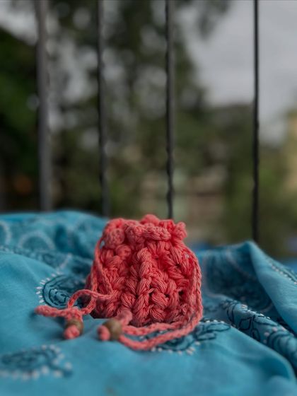 A simple yet beautiful shot of my pink potli pouch. The textured stitch and beaded drawstrings make it a special little bag for your treasures.