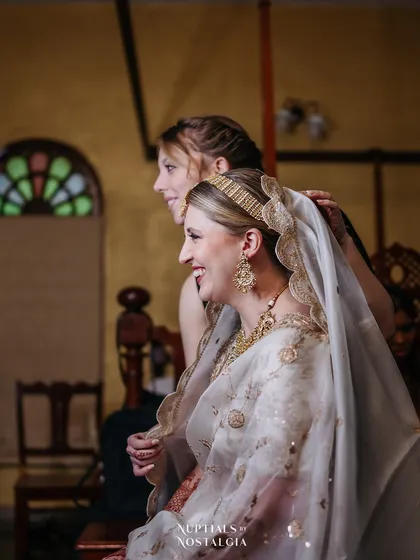 A bride gets help with her veil, a beautiful, candid moment captured in the warm, ambient light of one of our suites.