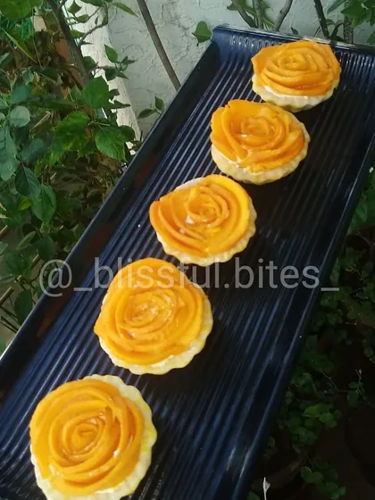 My elegant Mango Rose Tartlets, crafted to celebrate mango season. Each tartlet has a crisp biscuit base filled with cream and topped with fresh mango slices arranged in a beautiful rose pattern.