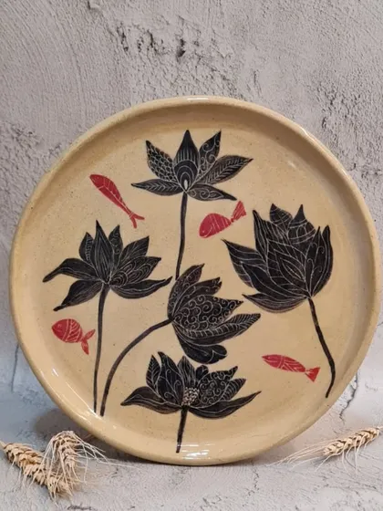 My signature Sgraffito technique allows for intricate, hand-carved designs like the lotus and fish on this plate. This artistic style brings a unique, nature-inspired story to your tableware collection.