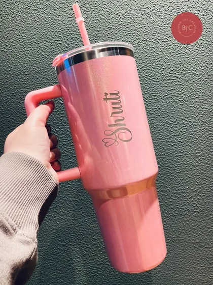 Holding up our new glam tumbler to show off the beautiful personalised script. It's travel friendly and keeps your drinks insulated for hours.