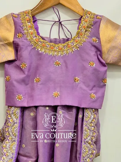 A beautiful lavender blouse with a heavily embroidered neckline. This piece can be paired with a lehenga or a saree.