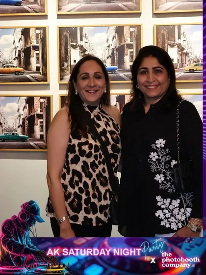Two guests posing at the 'AK Saturday Night Party'. The instant prints serve as a great party favor for everyone to take home.