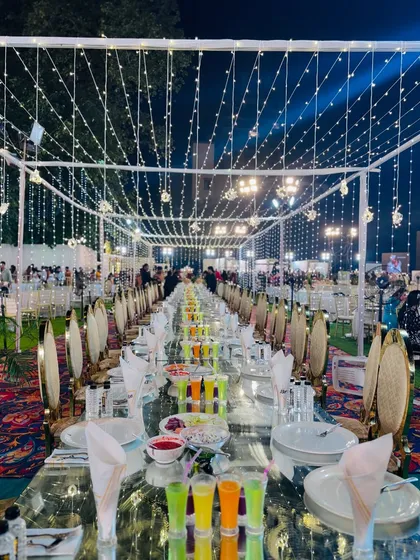 A breathtaking view of the long dining tables under a canopy of fairy lights, creating a truly romantic and grand ambiance.