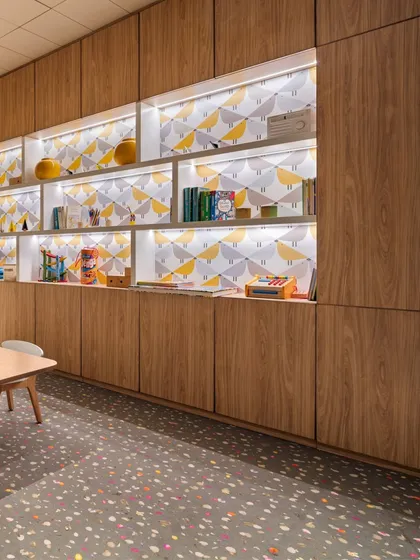 The kids' play area at the Elevate Clubhouse is a testament to our human-centric approach. We introduced natural light through new windows and designed playful, illuminated shelving with whimsical wallpaper, transforming the space into a bright and engaging haven for children.