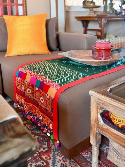 A throw designed for spring, combining green Bandhni and Gajji silk fabrics with a vintage Kutch border. The piece is reversible, with a beautiful floral fabric on the back for a different look.