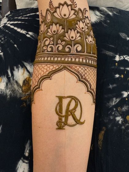 A beautiful initial monogram framed by a traditional arch and topped with a band of lotus flowers. This is the design with the fresh henna paste.