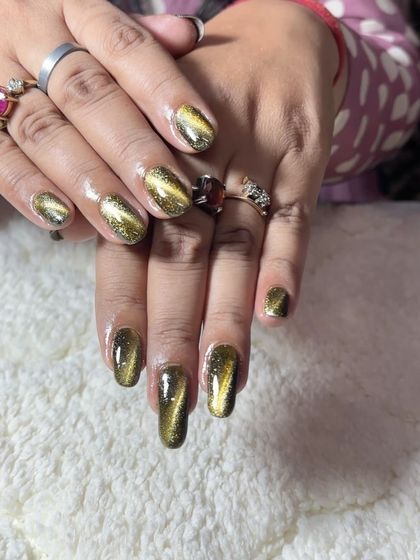A stunning gold cat-eye effect on short, square nails. The magnetic polish creates a vibrant, shifting line of gold.