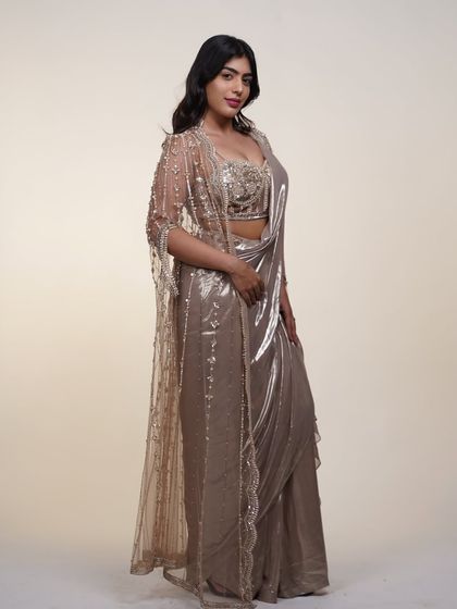 This metallic pre-draped saree comes with a stunning sheer cape, adding an extra layer of drama and elegance to your look.