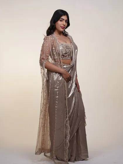 This metallic pre-draped saree comes with a stunning sheer cape, adding an extra layer of drama and elegance to your look.