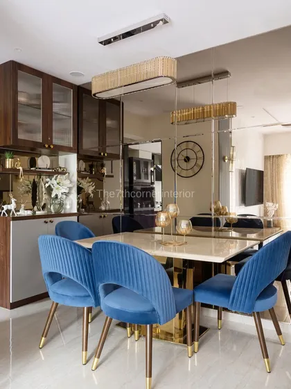This dining space from 'The Adobe' project was designed to feel both grand and intimate. The deep blue upholstered chairs provide a rich pop of color against the Italian marble tabletop, while the mirrored wall cladding visually expands the space, creating an elegant setting for memorable meals.