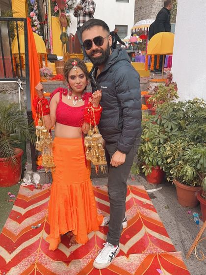 With my gorgeous bride on her Haldi day. She is wearing a vibrant orange and red outfit, and I gave her a fresh, minimal makeup look to match the occasion.