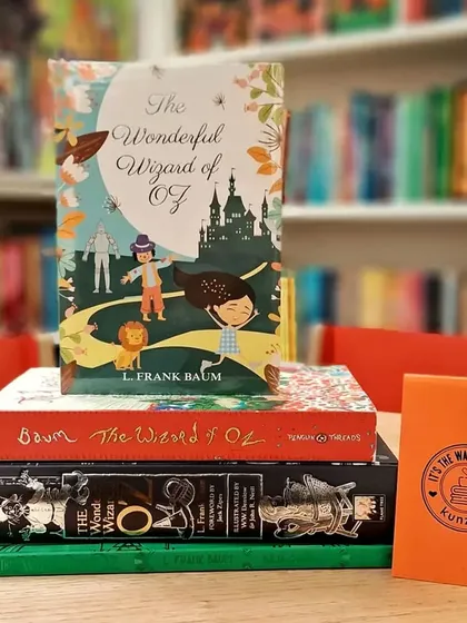 A stack of different editions of 'The Wonderful Wizard of Oz'. Each one offers a unique artistic take on the classic story.