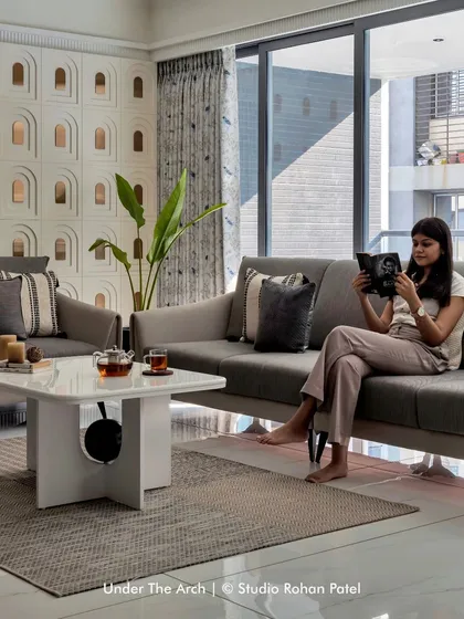 The living room is a serene and light-filled space, perfect for relaxation and reading.