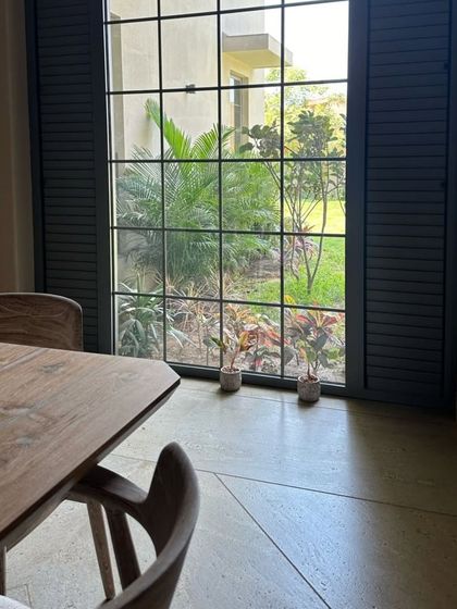 The charm of sandwiched Georgian bars in these system aluminum windows adds a classic touch to the facade, perfectly framing the garden view.
