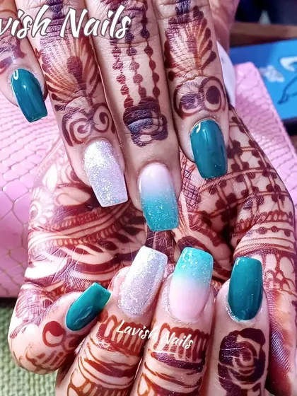 This design shows how beautifully colored nails can complement bridal mehendi. The set combines solid teal, white glitter, and a soft teal-to-nude ombré for a vibrant, photo-ready look.