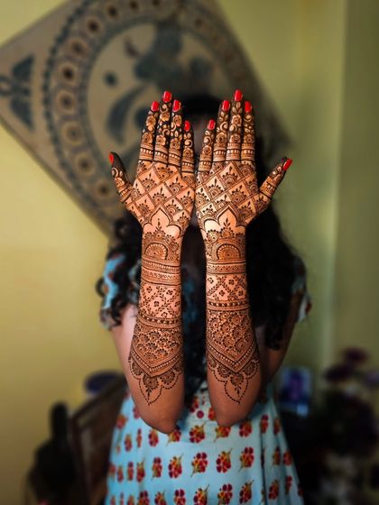 A full view of the rose-detailed bridal henna, showing the complete design from arms to fingertips.