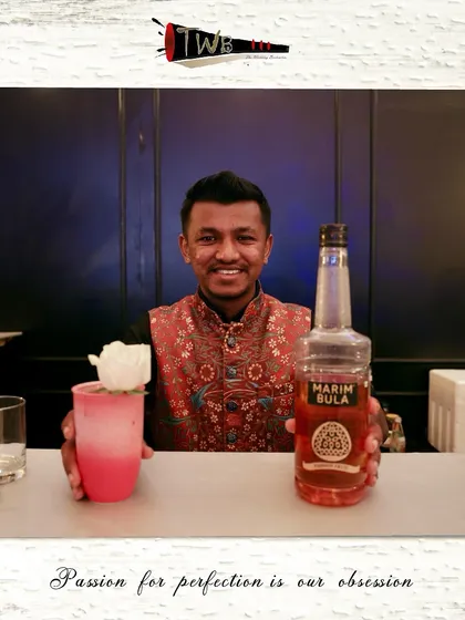 A bartender presents a rose-garnished cocktail, showcasing the artistic touches our team adds to each drink.