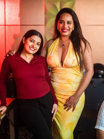 Two friends dressed in bright, happy colors for a night out.