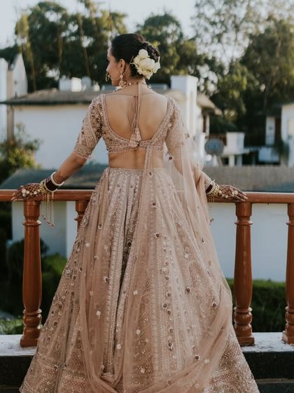 The back of the bride's outfit and her elegant floral bun. Every detail is curated to create a cohesive and beautiful bridal look.