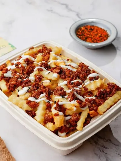Loaded fries with mince and sauce in a delivery box, looking hearty and ready to eat.