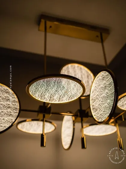 A close-up of the textured disc chandelier, detailing the intricate web-like pattern on the glass. This detail adds a layer of sophistication and visual interest to the fixture.