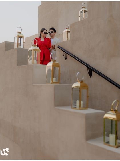 A couple sharing a quiet moment on a staircase adorned with lanterns in Dubai. The warm tones and soft lighting create a romantic and enchanting pre-wedding scene.