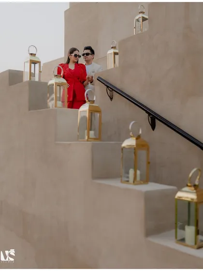 A couple sharing a quiet moment on a staircase adorned with lanterns in Dubai. The warm tones and soft lighting create a romantic and enchanting pre-wedding scene.