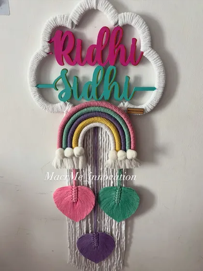 This double name hanging for Riddhi and Sidhi uses a lovely pastel palette with pink, green, and purple heart-shaped leaves. It's a sweet and coordinated piece for a shared room.