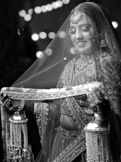 A black and white portrait of the bride holding her 'kalire', creating a classic and emotional image.
