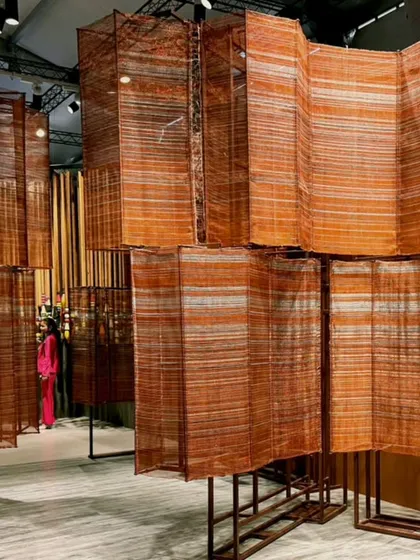 A wide view of the 'India Everywhere' installation, where hand-woven copper wire panels create a maze-like environment. The metallic sheen of the copper bridges tradition and industrial finishing.