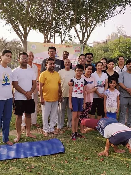 This is what our community looks like. We bring together people of all ages, from young children to seniors, for our outdoor yoga sessions in the park. Here I am demonstrating Mayurasana (Peacock Pose) for the group.