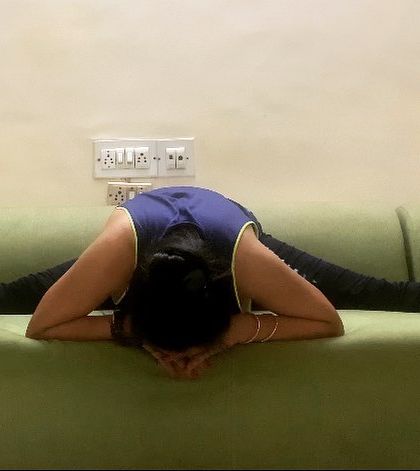 Making the best use of available resources. Here, I am using my sofa to deepen the stretch in a wide-legged forward fold (Upavistha Konasana).