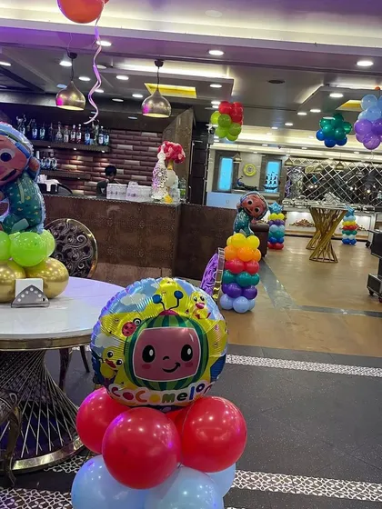 Another view of the Cocomelon table centerpieces and hanging balloon bunches that filled the party hall.
