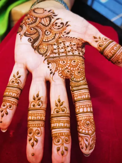 This design focuses on decorating the fingers with different patterns, connected to a simple motif on the palm. It's a very chic and modern style.