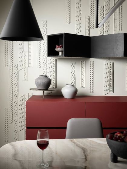 A close-up of the dining area shows how we infused the space with warmth and personality. The cherry red sideboard and custom wall paneling create a seamless transition from the kitchen, making this a perfect spot for everything from casual meals to formal entertaining.