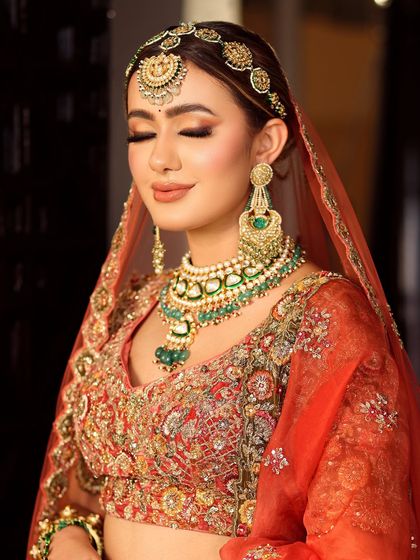 Eyes closed, the artistry shines through. This shot highlights the seamless eyeshadow blending and the soft, peachy tones that complement the bride's complexion.