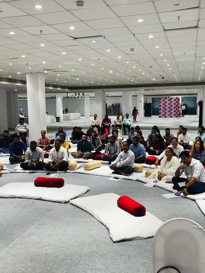 Participants in our corporate workshop arranged in a circle for an interactive session. This format encourages participation and creates a shared experience.