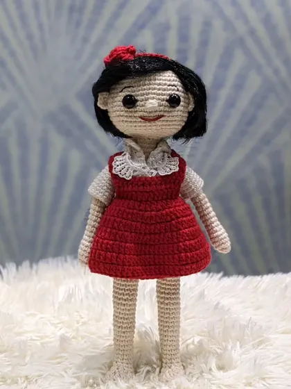 A full-length view of the custom doll in the red dress, showing the complete handmade creation.