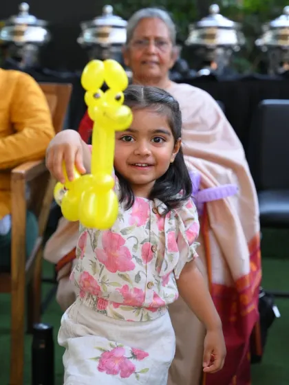 A happy guest with her new balloon animal. Our balloon artists can create a wide variety of designs, from animals and swords to hats and flowers, adding a colorful and interactive element to any event.