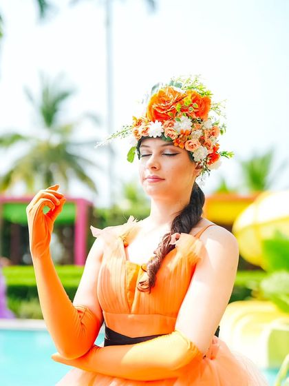 A performer with a beautiful fresh flower headpiece, perfectly capturing the boho chic aesthetic of the Haldi pool party.