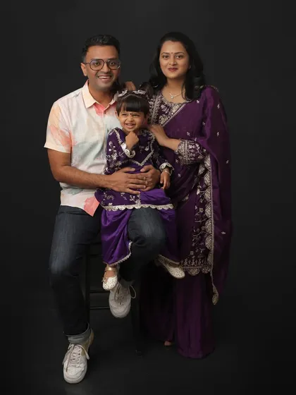 A classic family portrait is a treasure that lasts forever. Here, a family of three coordinates in beautiful shades of purple for a studio session, capturing their happy smiles and the playful personality of their little one.