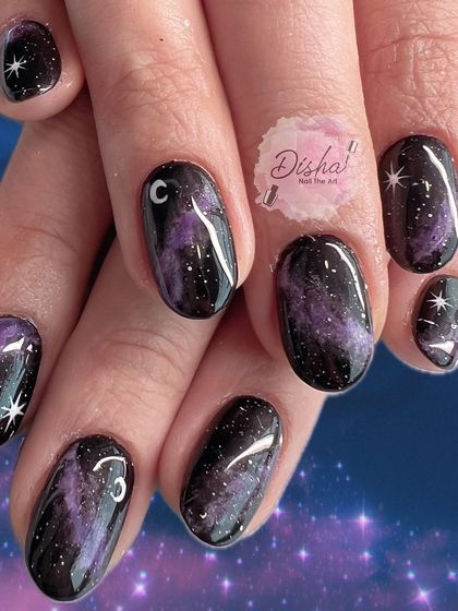The ever-so-loved galaxy nails. A full look at this cosmic design with a purple and black nebula and sparkling stars.