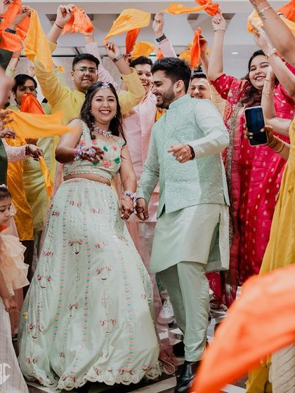 The couple makes a grand, dancing entrance at their Haldi ceremony, surrounded by friends waving colourful scarves. We capture the energy from the very first moment.