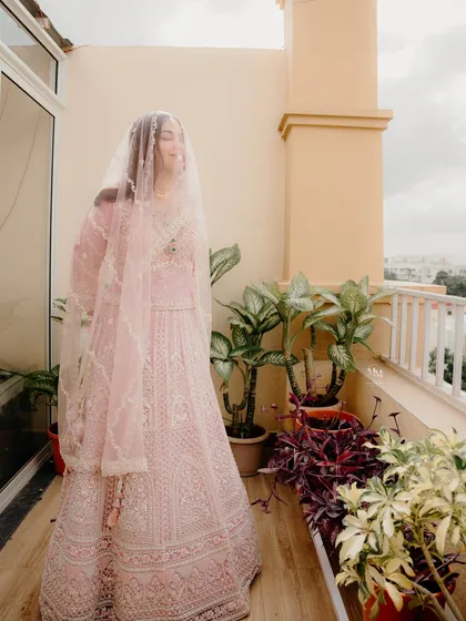 A candid shot of the bride on a balcony, her veil flowing in the breeze. This photo feels natural, happy, and full of life.