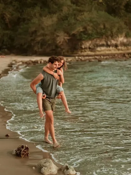 A fun and energetic piggyback ride on a beautiful beach in Bali. This candid moment perfectly captures the couple's playful dynamic during their destination shoot.