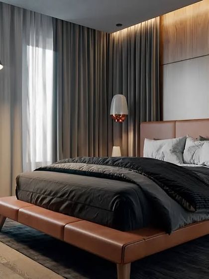 This bedroom design exudes warmth and comfort. We used a wood-paneled feature wall behind a tan leather bed, complemented by an elegant arc floor lamp and hanging bedside lights to create a cozy and inviting atmosphere.