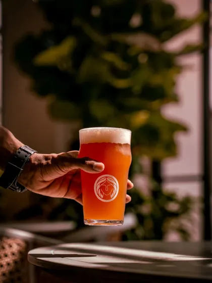 I take pride in my crafthouse. This is one of our 16 craft beers, brewed right here. It's a taste of our passion for quality, perfect for enjoying in the golden hour light.