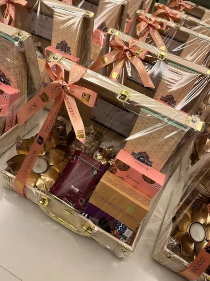 A close-up of our 2024 Diwali gift for Priyablue Shipping, packed in a beautiful wooden trunk. We ensure every detail, from the products to the branded ribbon, is perfect.